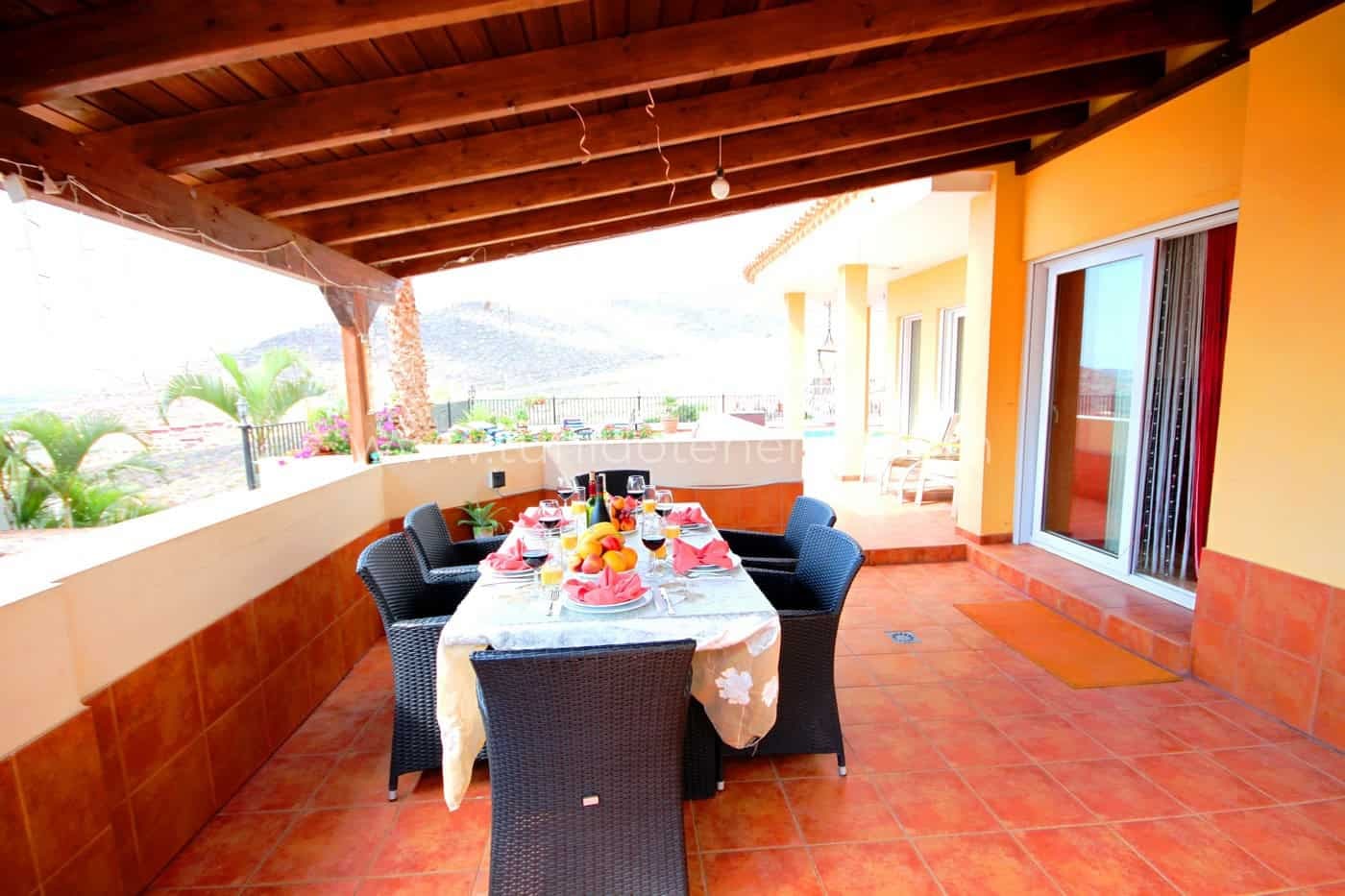 Terrasse couverte avec table et chaises près de la maison