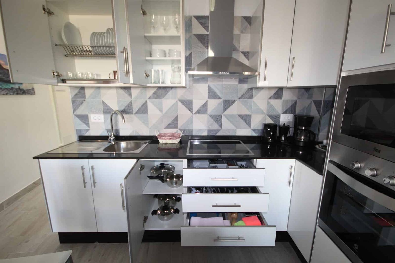 Cucina moderna con armadietti bianchi ed elettrodomestici integrati