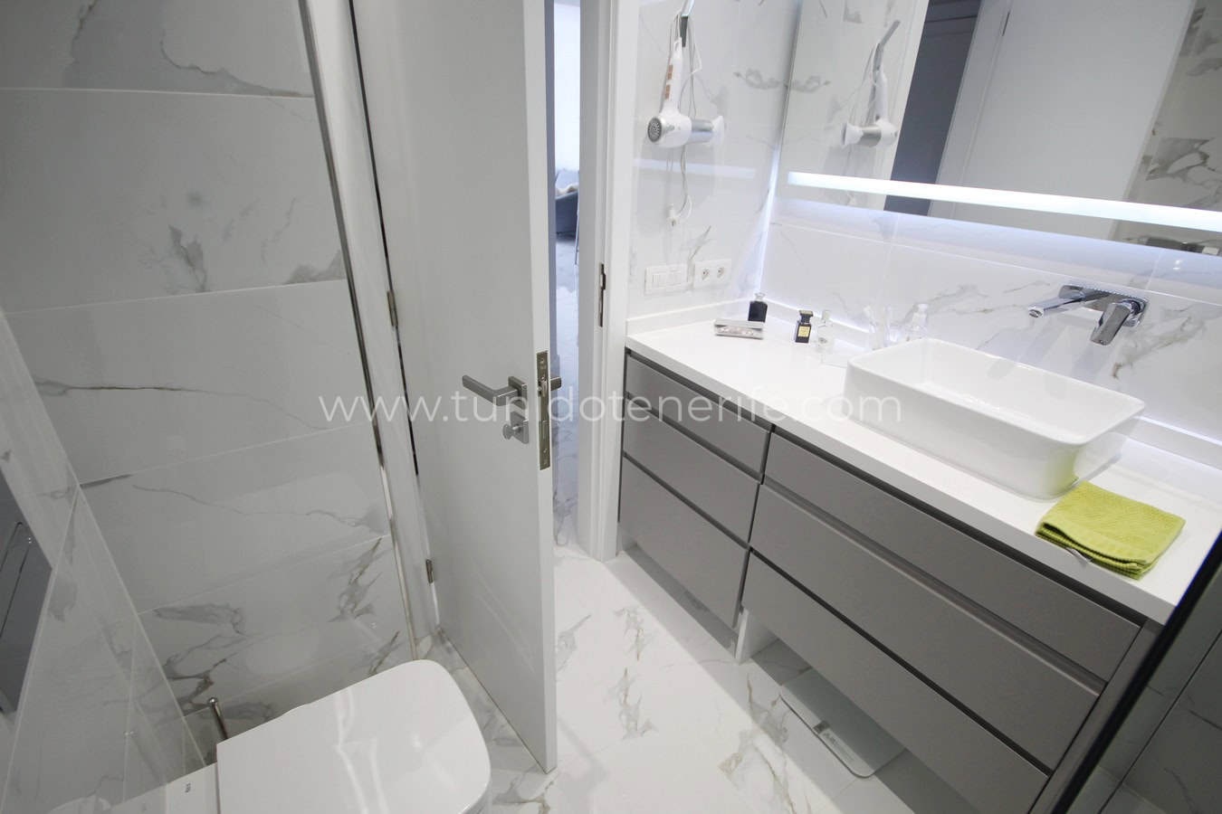 Modern bathroom with shower, sink and gray vanity