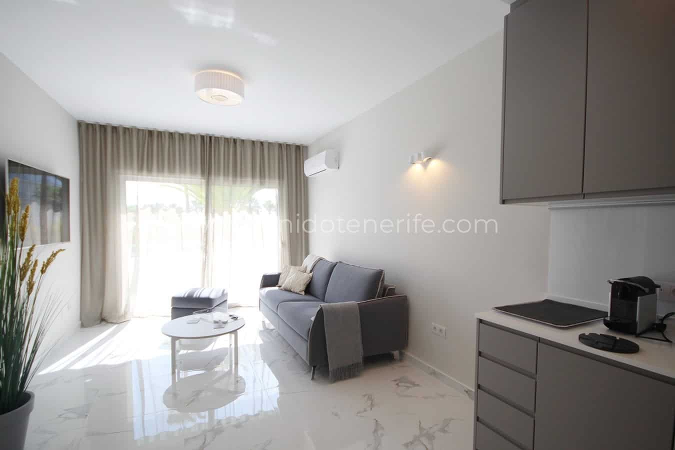 Bright living room with gray sofa, white table and beige curtains