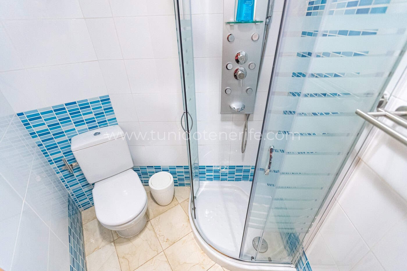 Baño pequeño con ducha de cristal y azulejos azules