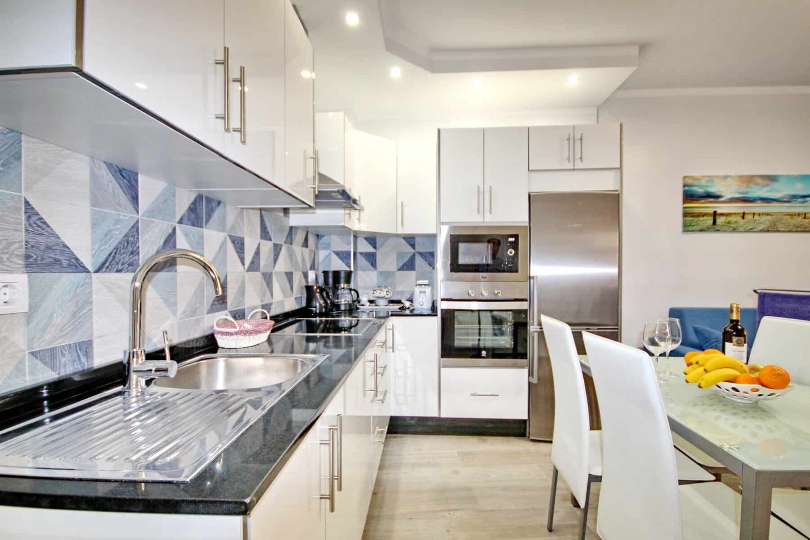Cucina moderna bianca con piano nero e zona pranzo