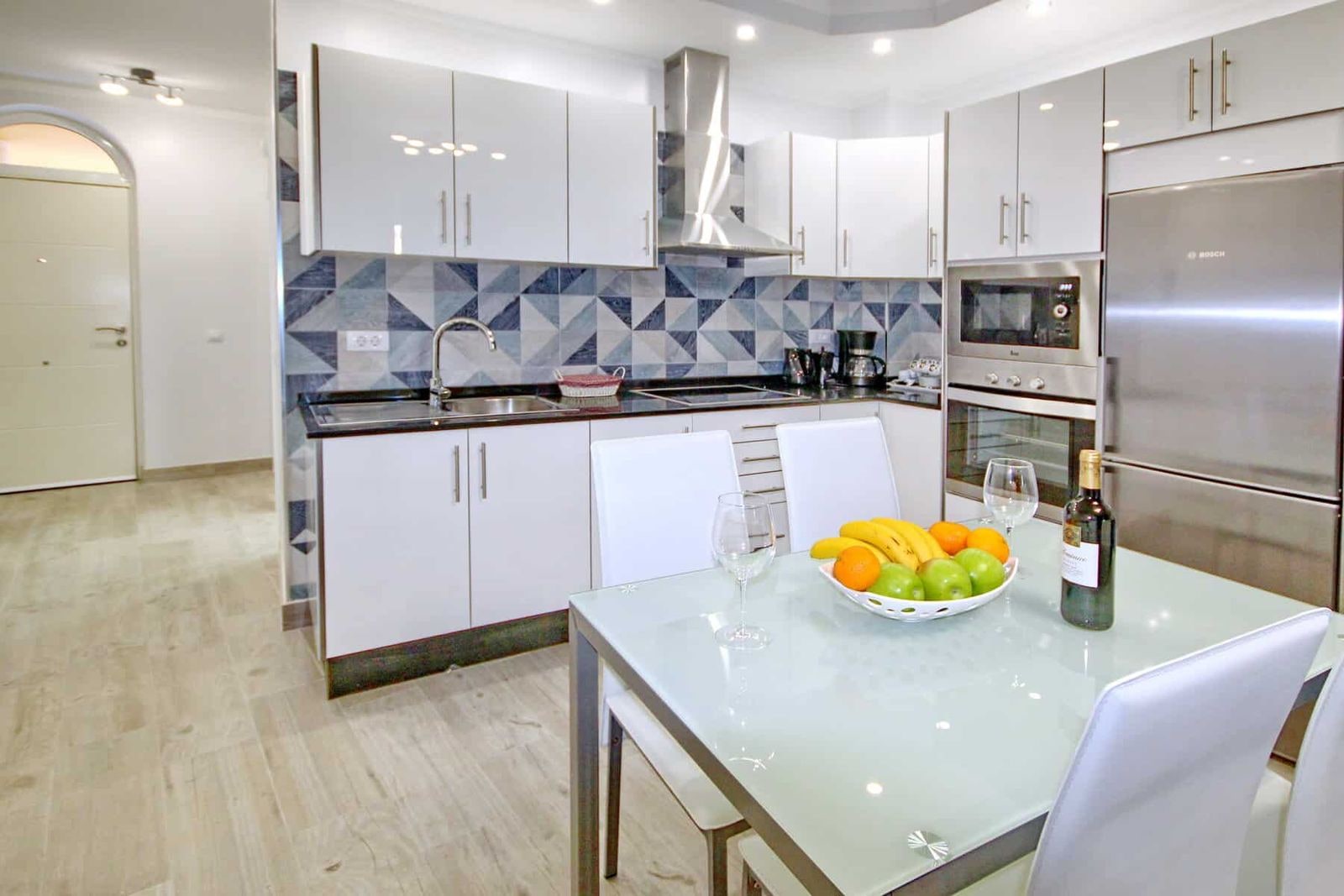 Cucina moderna con tavolo in vetro ed elettrodomestici inox