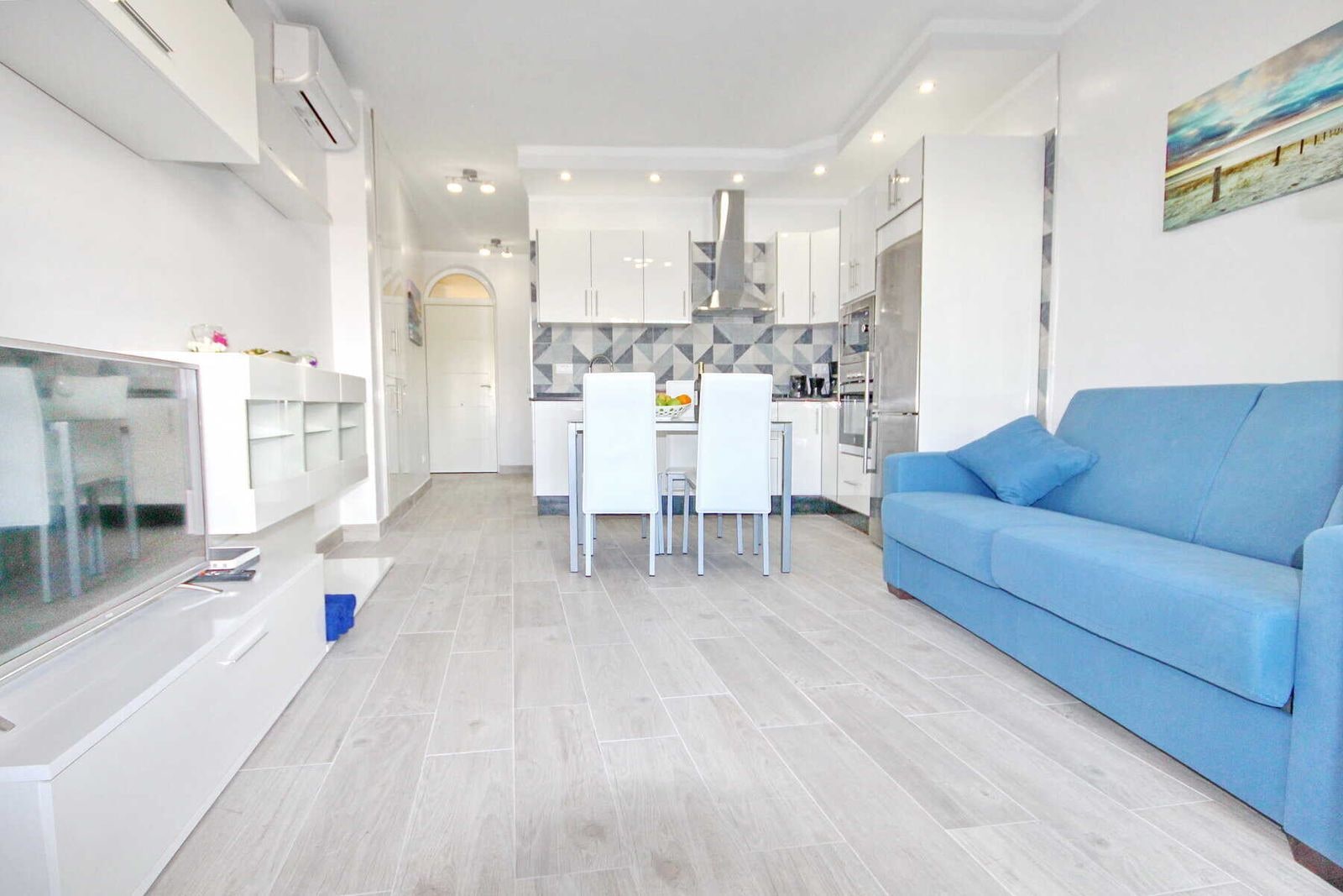 Soggiorno moderno con divano blu e cucina aperta