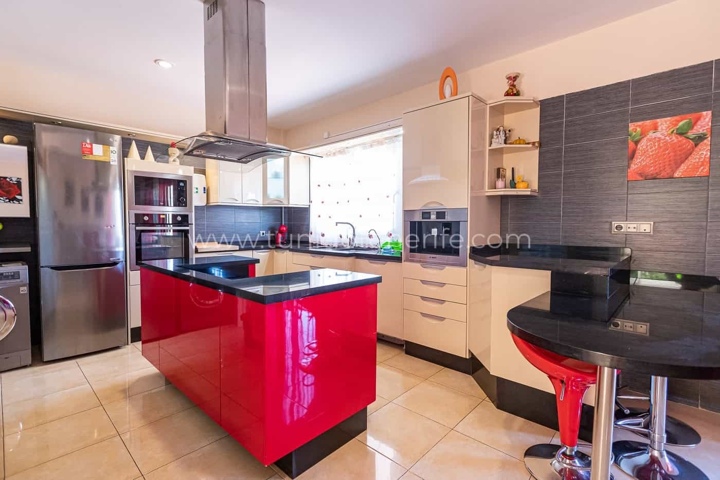 Cuisine moderne avec îlot rouge et électroménager en inox