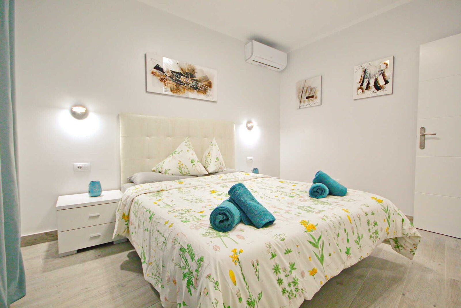Camera da letto con letto matrimoniale, comodini e arredo floreale