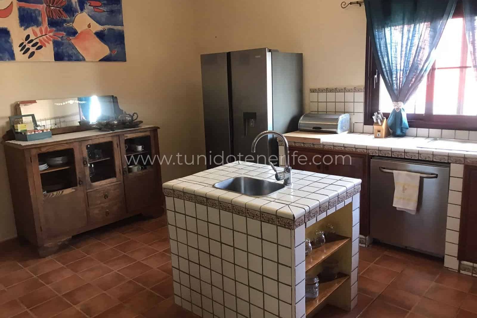 Kitchen with central island, sink, cabinets and window