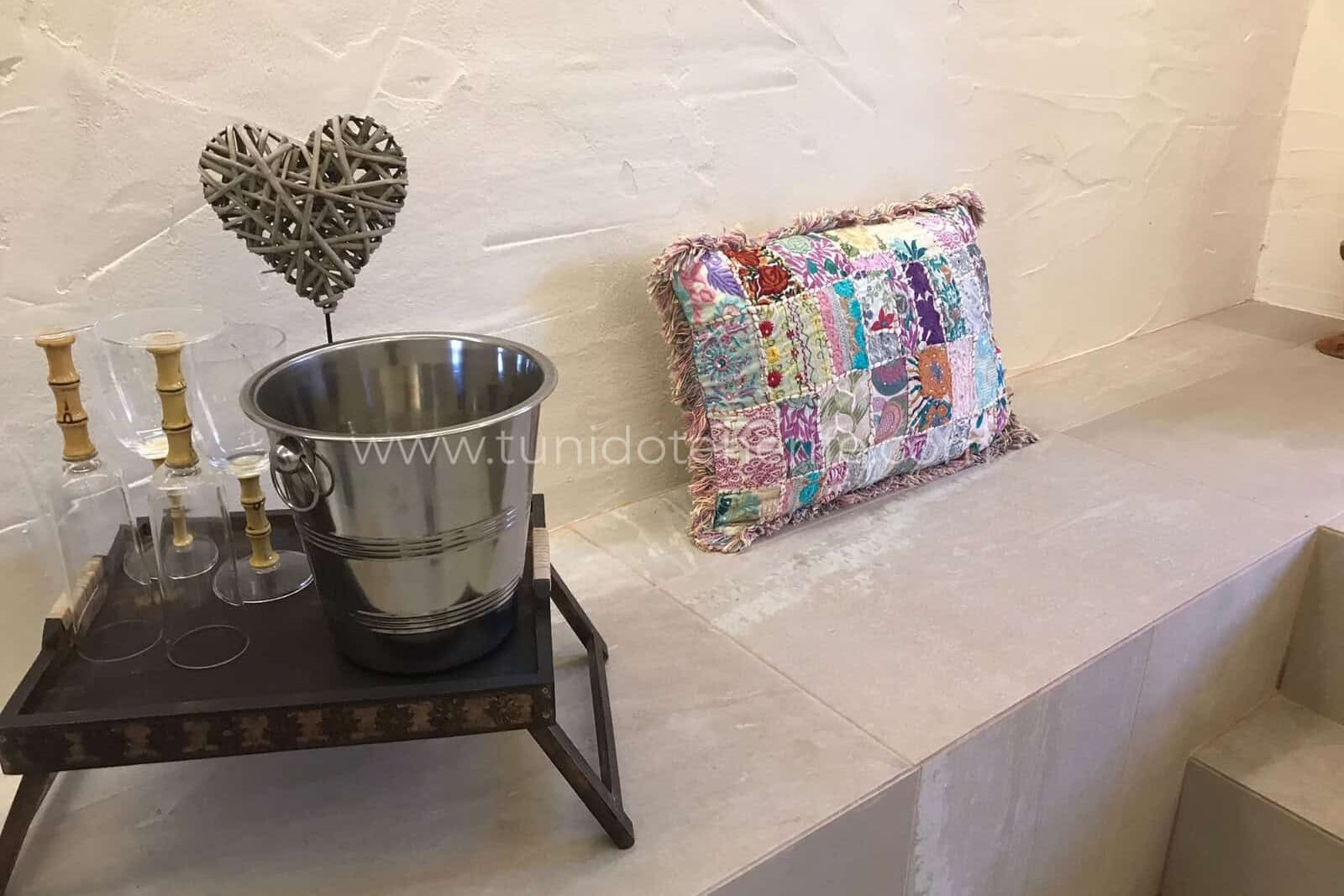 Built-in bench with decorative cushion and metal bucket