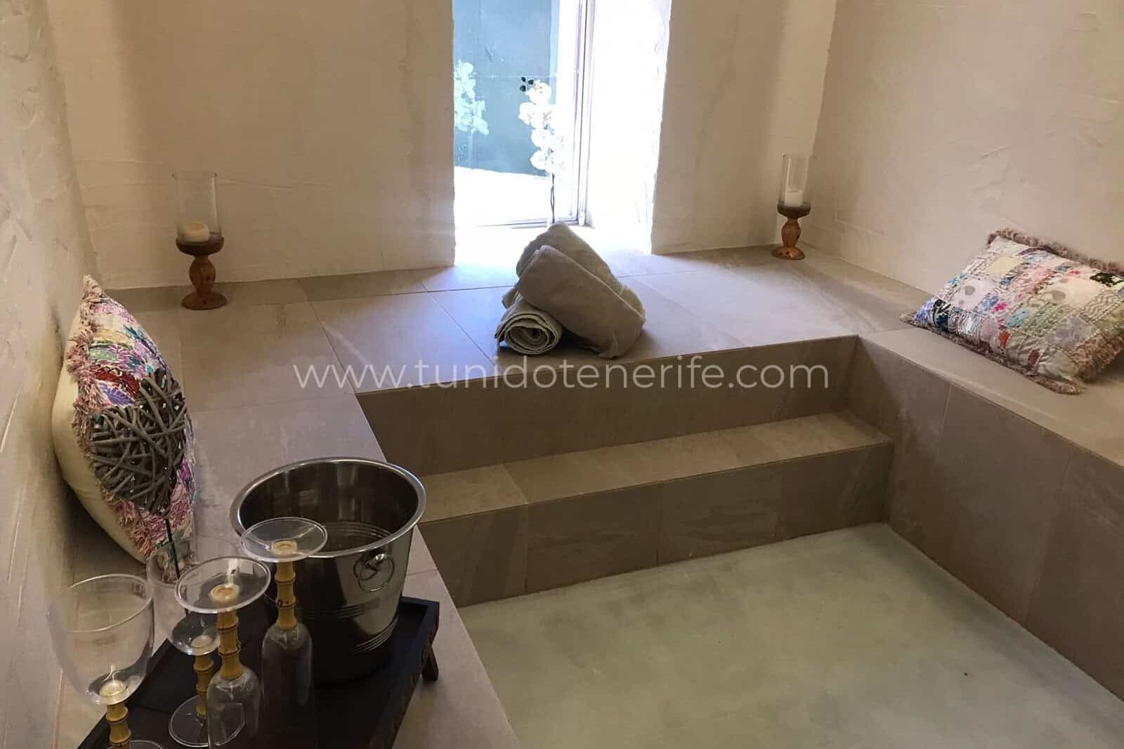 Room with central step, decorative cushions and outdoor exit