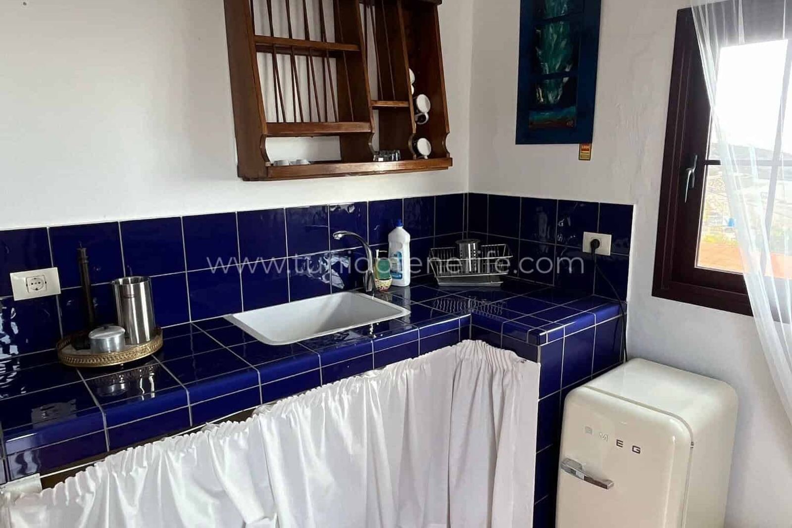 Kitchen with blue tiled countertop and sink