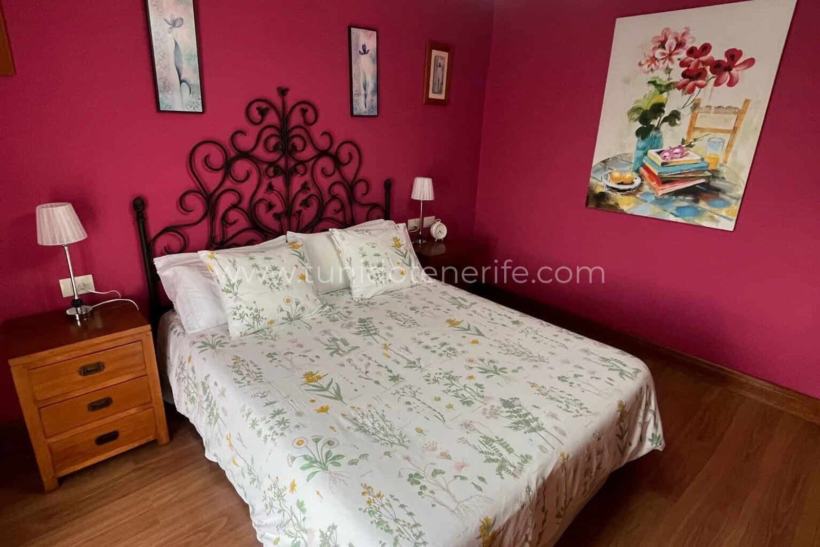 Bedroom with double bed, bedside tables and fuchsia walls