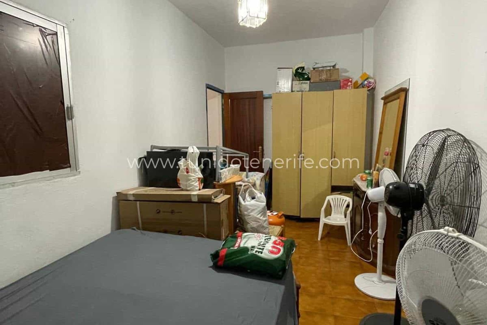 Simple bedroom with wardrobe, mirror and fans