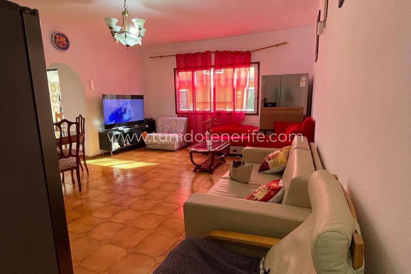 Spacious living room with sofas, television and red curtains