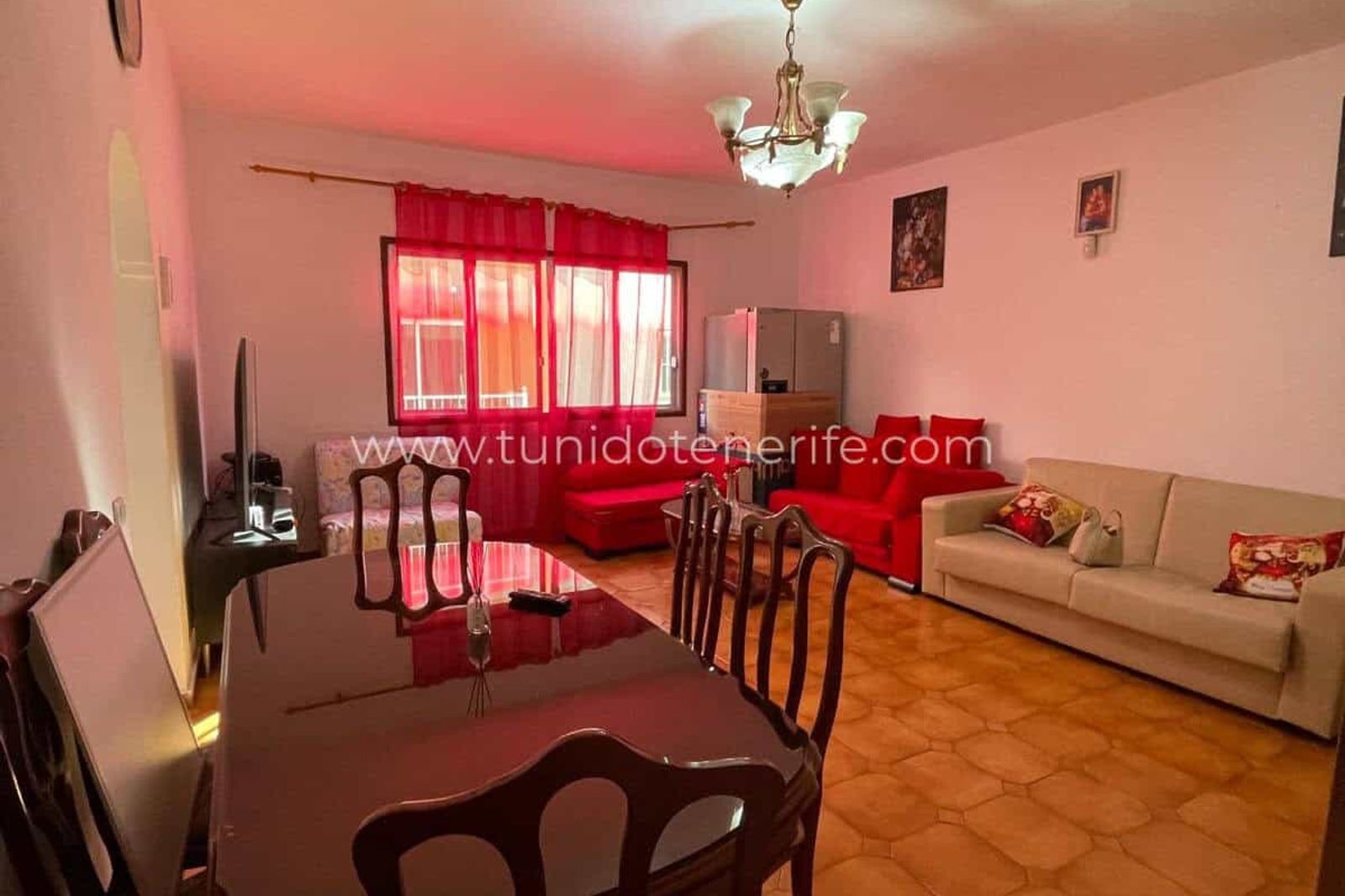 Living room with red sofa, dining table and curtained window
