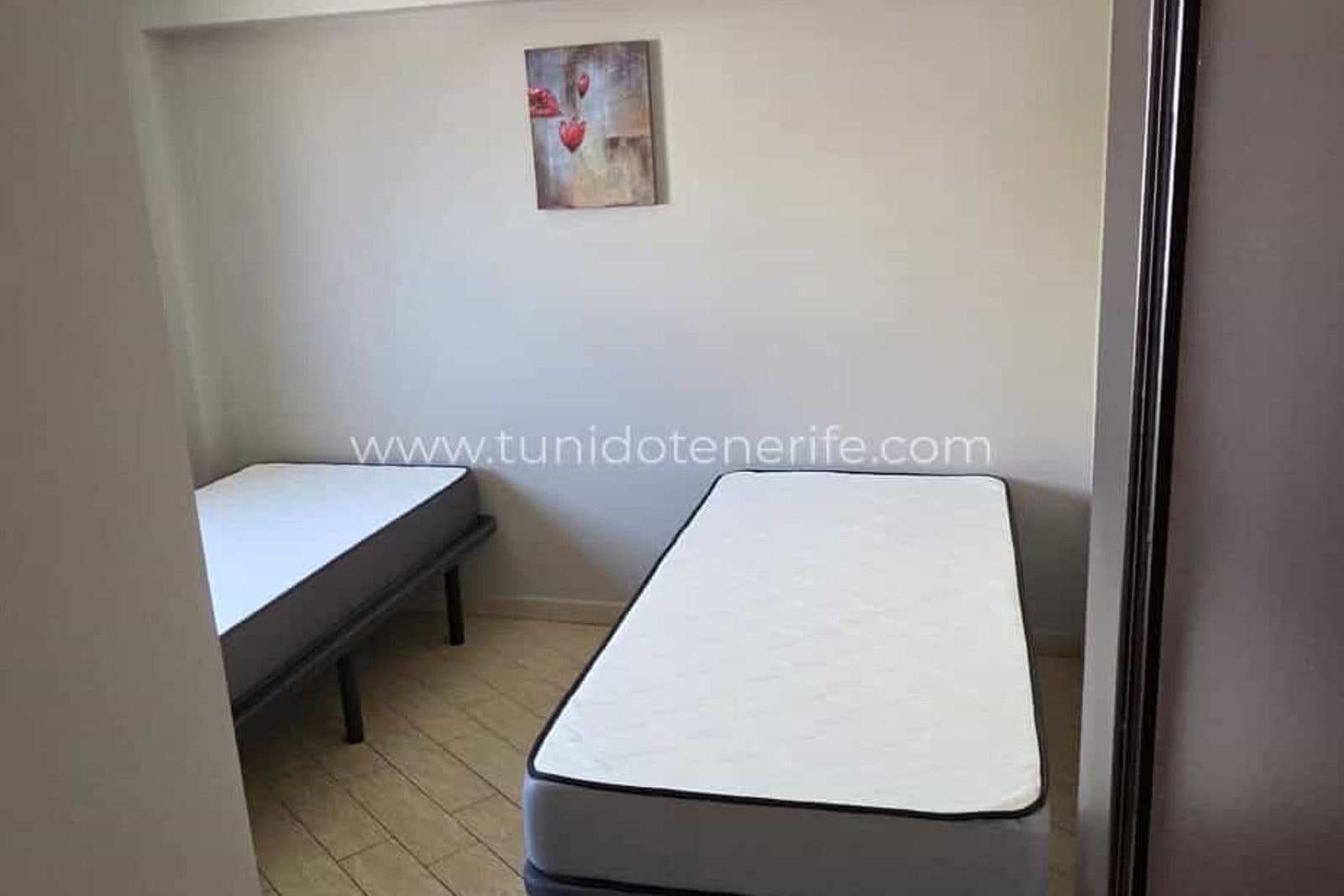 Dormitorio pequeño con dos camas individuales y pared decorada
