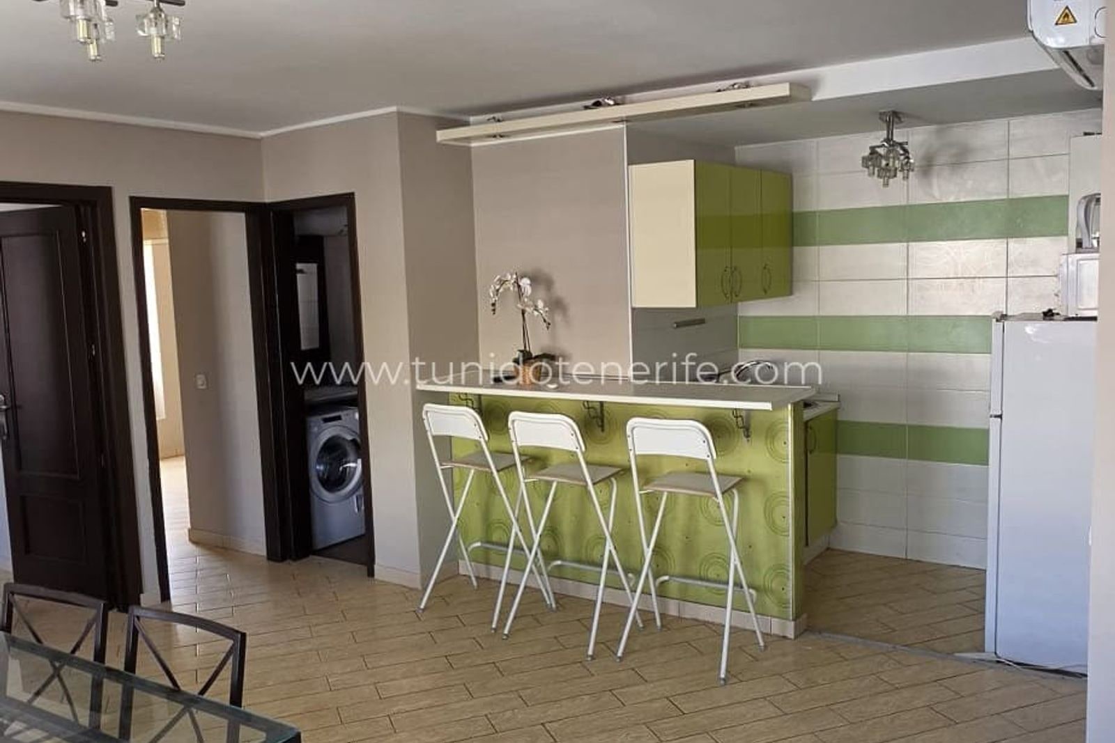 Cocina abierta con barra y taburetes blancos
