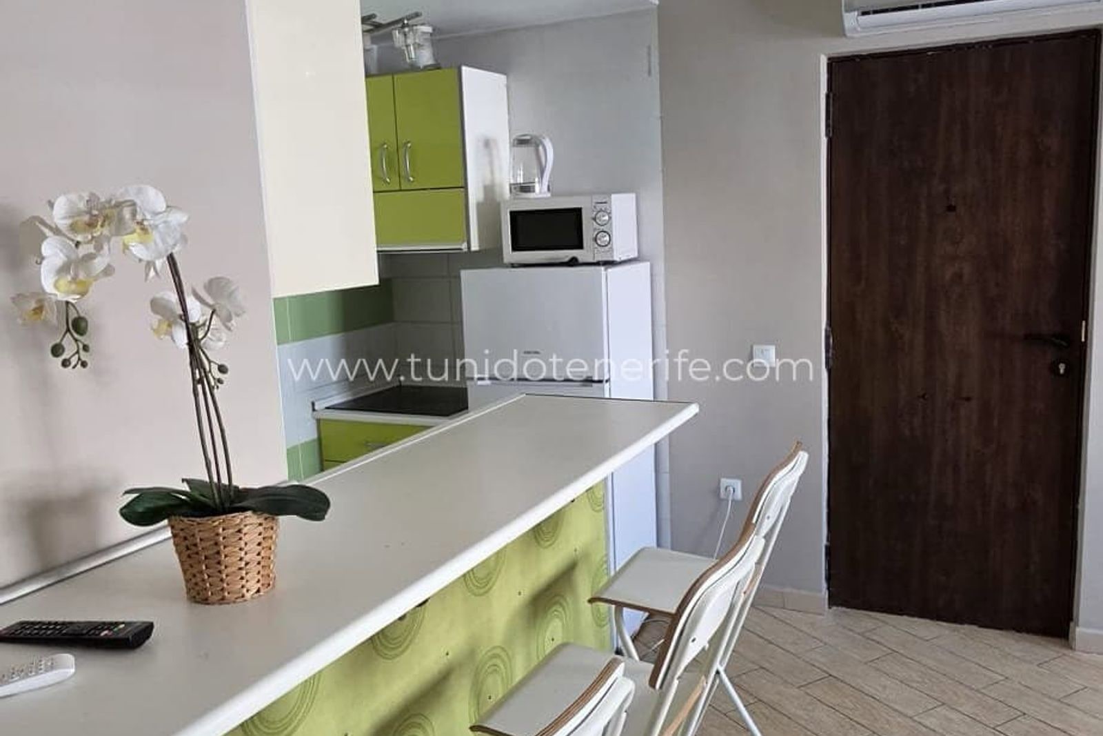 Cocina abierta con barra y taburetes blancos