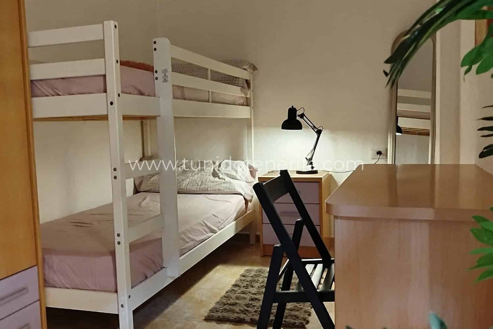 Dormitorio con litera blanca, escritorio y lámpara