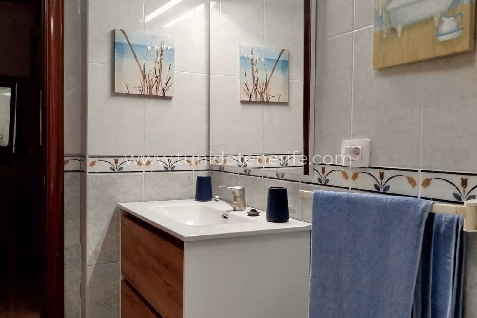 Baño con mueble lavabo blanco y espejo grande