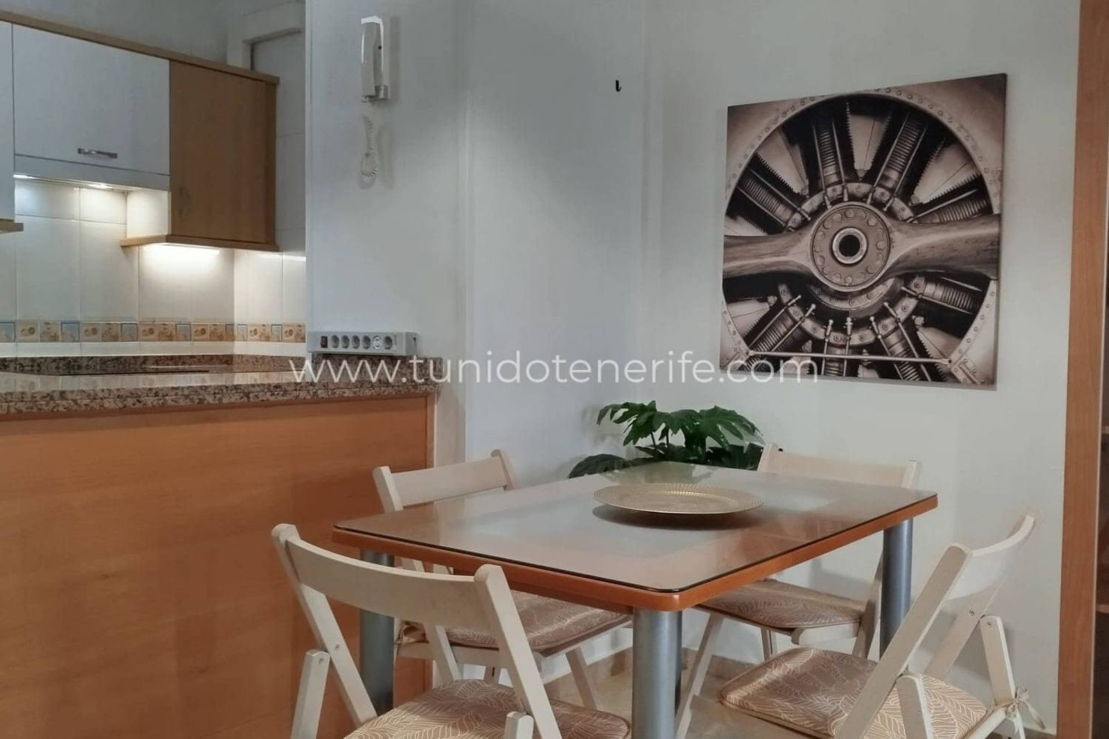 Comedor con mesa, sillas y cocina abierta