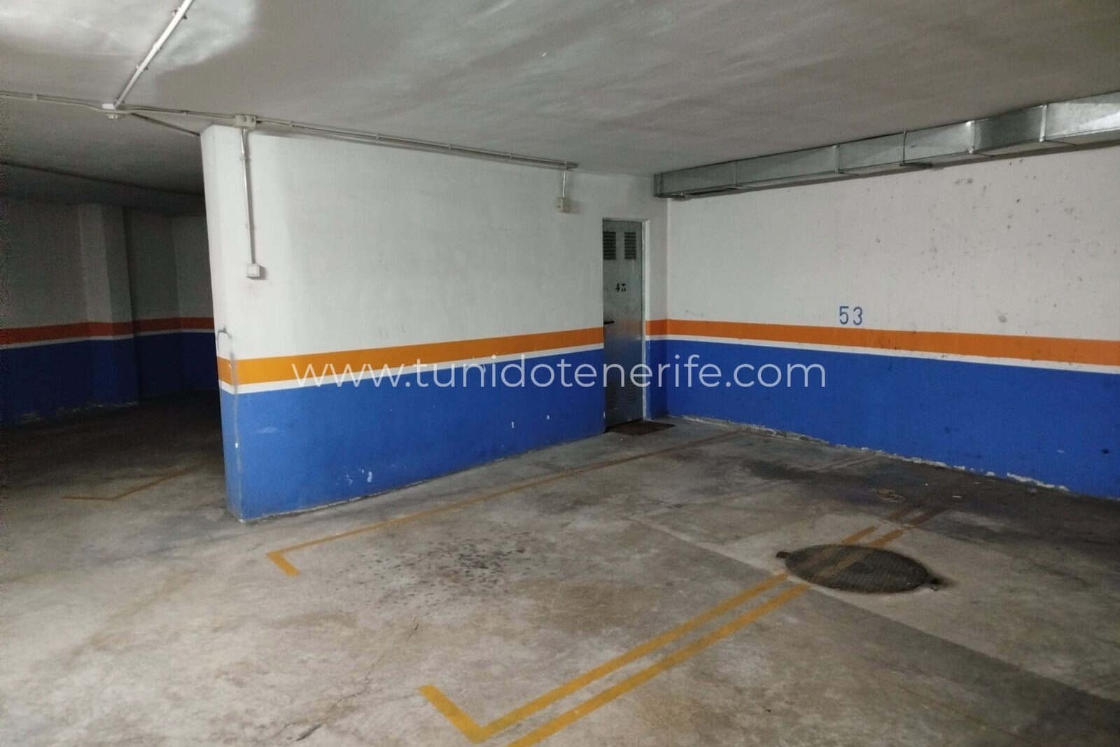Plaza de garaje subterránea con paredes pintadas y suelo de hormigón