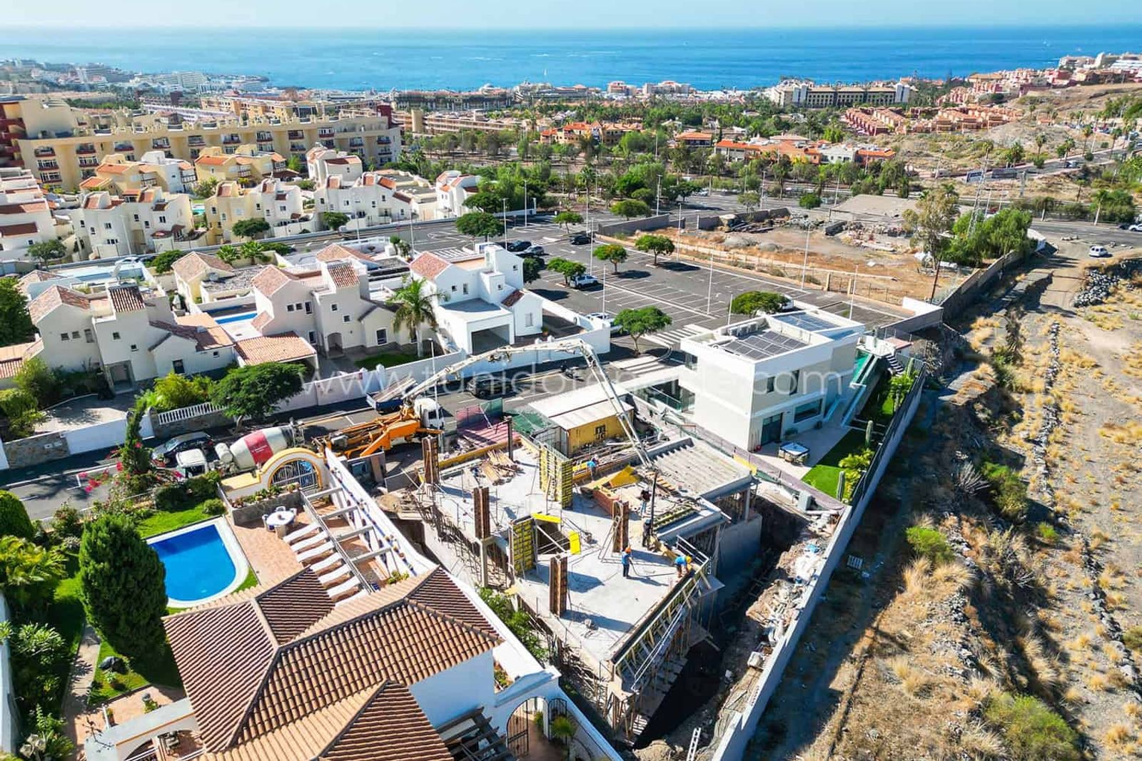 Aerial view of houses, streets and sea in the background